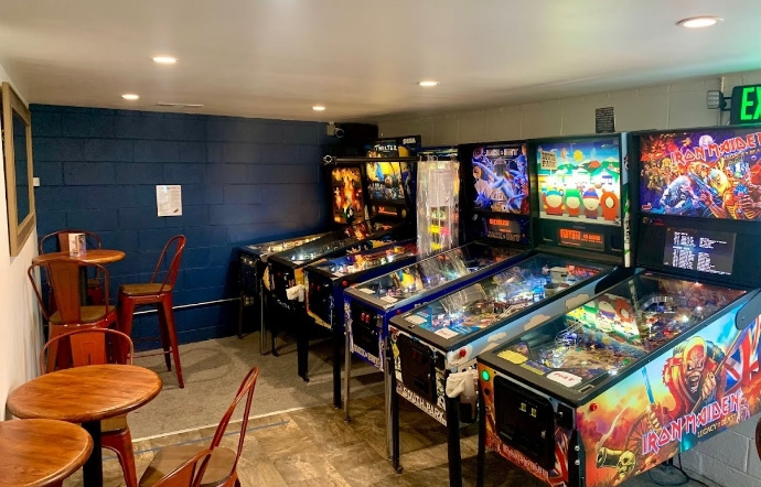 Man playing on pinball machine.